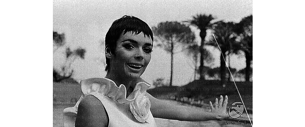Barbara Steele sorridente e con un braccio teso, sul bordo della piscina dell'Hotel Hilton; medio primo piano