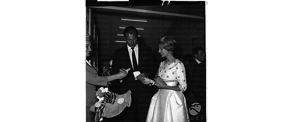 Una hostess della Panam consegna una rosa alla compagna di Lex Barker che entra al teatro Eliseo per lo spettacolo - piano americano