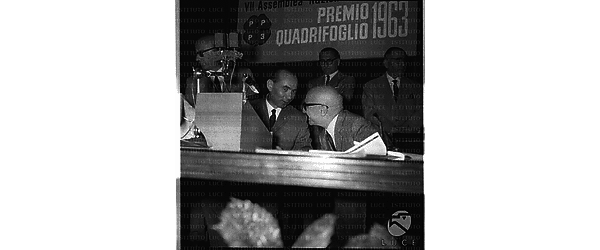 Paolo Bonomi al tavolo degli oratori conversa con un uomo in occasione della consegna del Premio Quadrifoglio ai Clubs 3P - piano americano