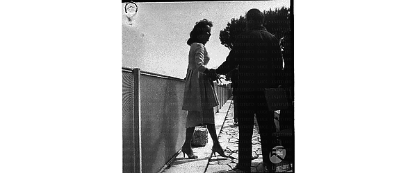 Elisabeth Taylor e Michael Todd (di spalle) ripresi in un esterno (forse di qualche villa) durante un servizio fotografico - totale