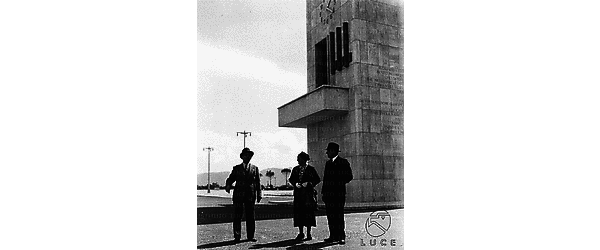 Sabaudia Frank, la moglie Brigitte e Marpicati conversano vicino alla Torre Civica o Littoria