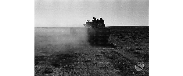 Un camion con soldati italiani a bordo avanza nel deserto sollevando una nuvola di polvere