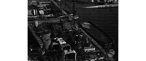 Pezzi di navi da guerra francesi allineati su un molo del porto di Tolone, una nave francese semi-affondata a lato