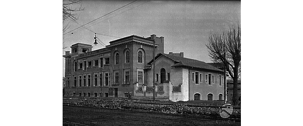 Il grande edificio scolastico (attuale scuola elementare L. Vaccari), quasi ultimato, visto in scorcio lungo viale Angelico. Il viale � occupato da lavori stradali in corso - Campo lungo