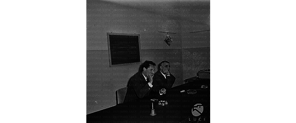 Pietro Germi mentre parla seduto al tavolo; al suo fianco Mario Monicelli