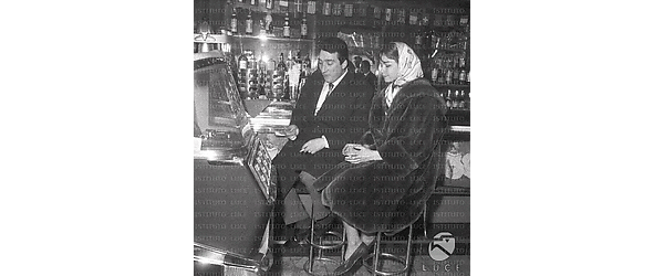 Toni Dallara e Lorella De Luca seduti vicino al juke box del bar