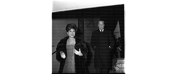 Sandro Pallavicini ed una donna (forse la moglie) ripresi all'arrivo al cinema Archimede in occasione della prima del film La Parmigiana - totale