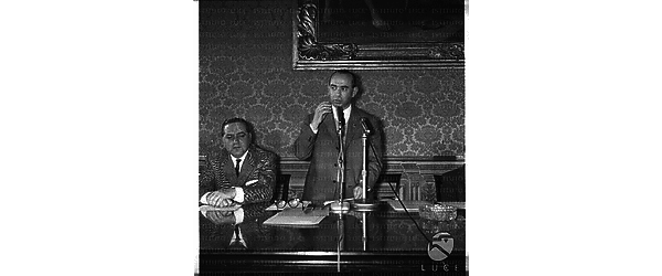 Ripreso Paolo Bonomi in occasione di una conferenza stampa in piedi accanto ad un uomo - piano americano