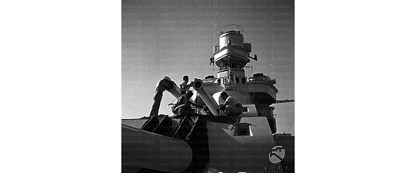 Marinai lavorano alla manutenzione dei cannoni di una nave da guerra italiana
