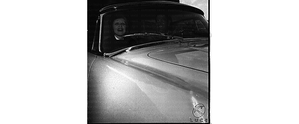 Marlene Dietrich ripresa sorridente sul sedile di un'automobile, accanto a Raf Vallone - piano medio