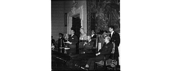 Egidio Ariosto al Campidoglio tiene un discorso  in occasione della commemorazione di Eleonora Duse, seduto accanto è l'onorevole Lupinacci - campo medio