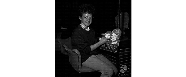 La cantante Rita Pavone ripresa in pausa, seduta su uno sgabello in un locale